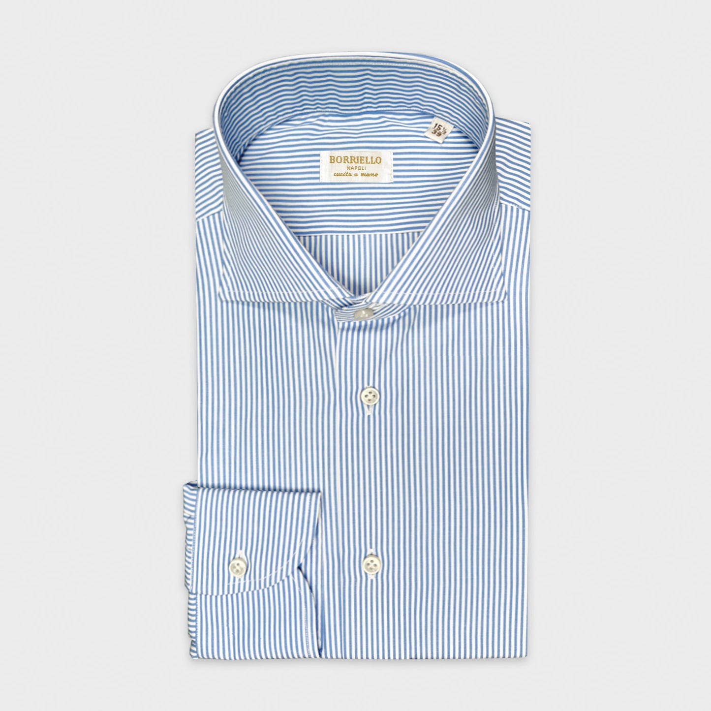 Chemise bleu clair à rayures blanches en popeline de coton. Chemise classique à rayures bleu clair et blanches, confectionnée main en Italie avec du tissu popeline de coton italien. Achetez Wools Boutique Uomo à Genève.