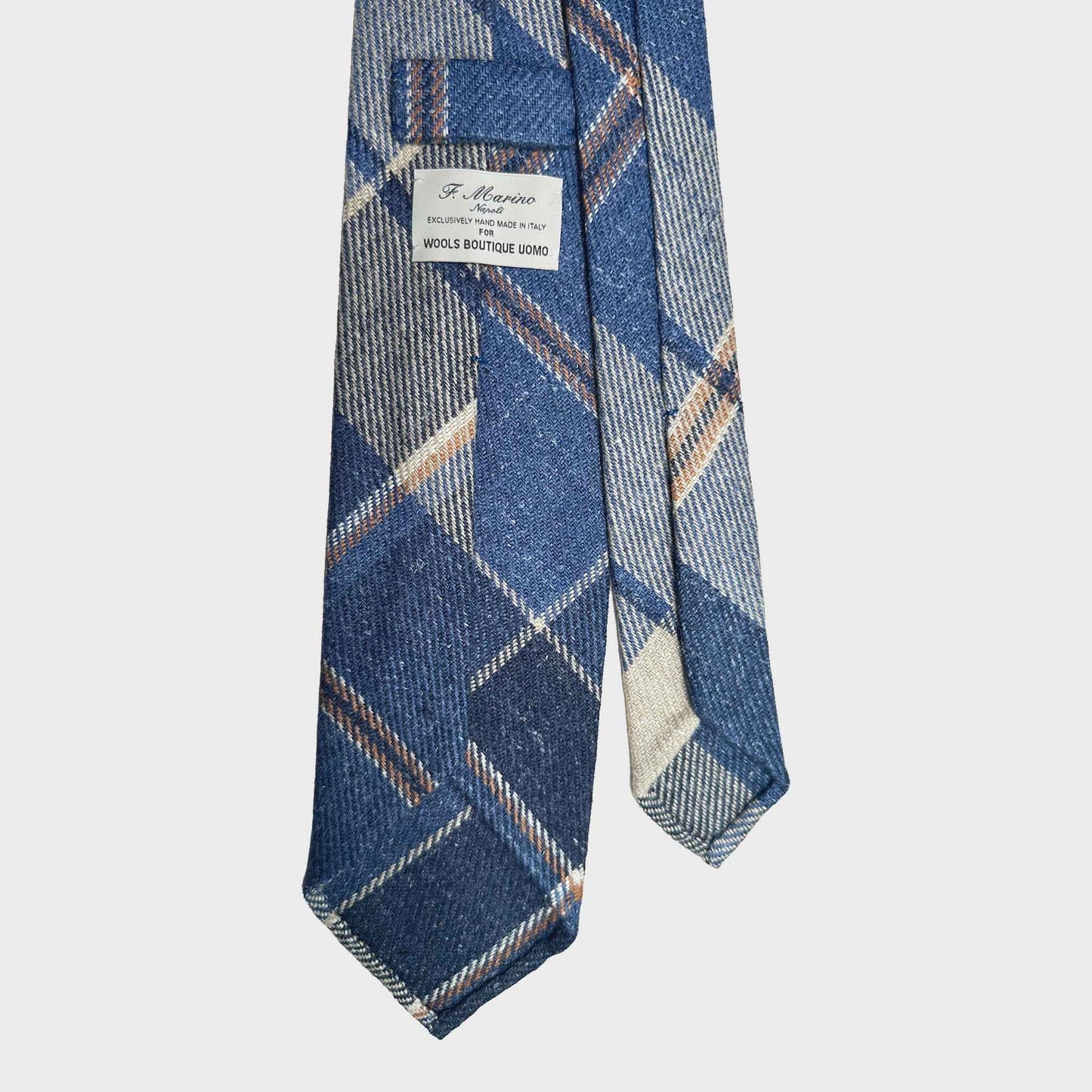 Exclusive wool ties available at men's ties store Geneva Wools Boutique Uomo, denim blue background, ocra and white windowpane pattern