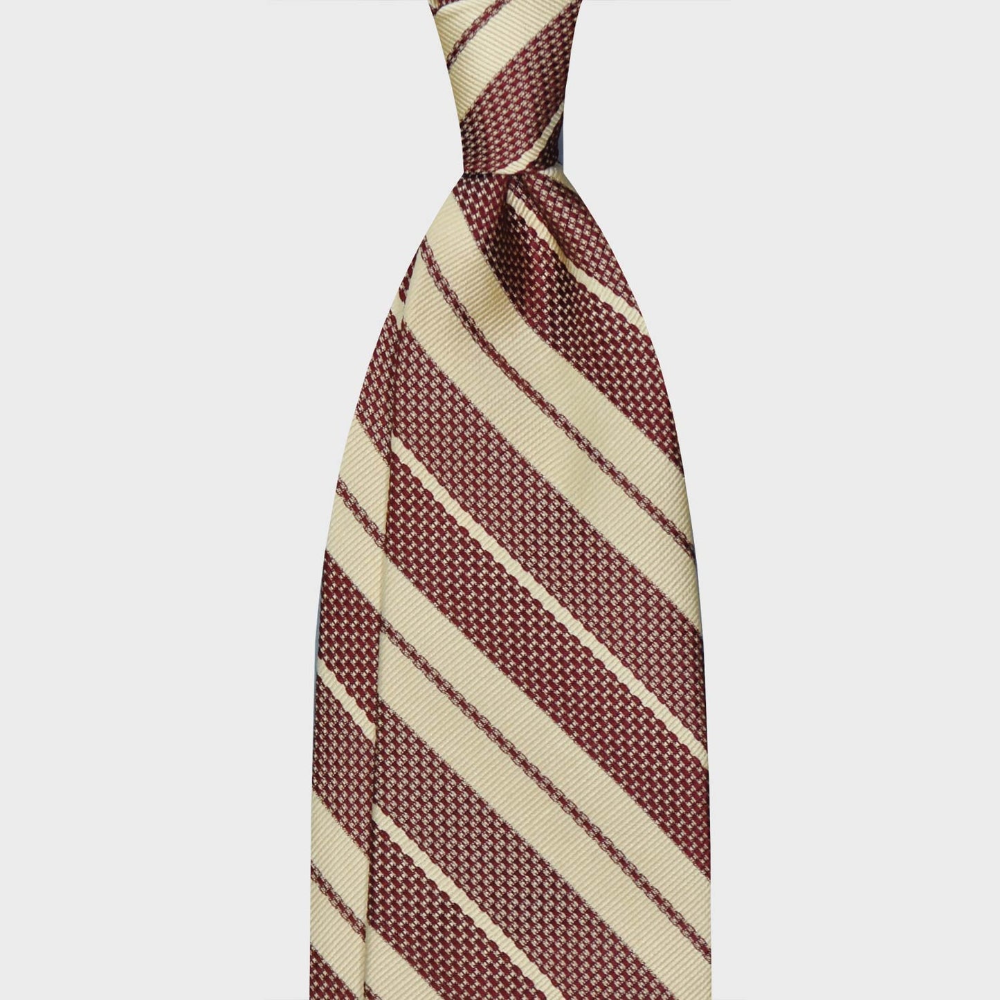 Hay Yellow Grenadine Silk Striped Tie. Regimental grenadine necktie made with grenadine and jacquard silk, hand rolled edge, unlined 3 folds, soft hay yellow background with burgundy red striped, F.Marino Napoli exclusive for Wools Boutique Uomo. Yellow Grenadine Silk Striped Tie Shop Switzerland