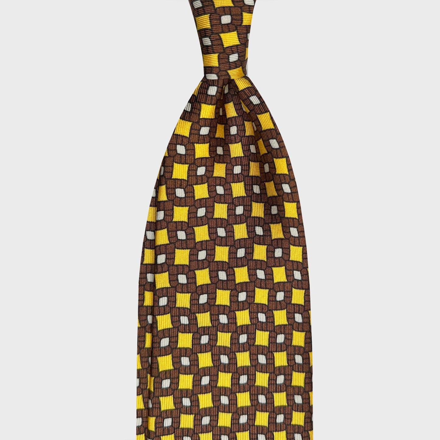 Cravate Soie Jaune Geneve Motifs Losanges Vintage. Cravate raffinée en soie jaune à motif vintage, fabriquée à la main en Italie exclusivement pour Wools Boutique Uomo à Genève, fond jaune citron à motif losanges vintage marron et blanc.