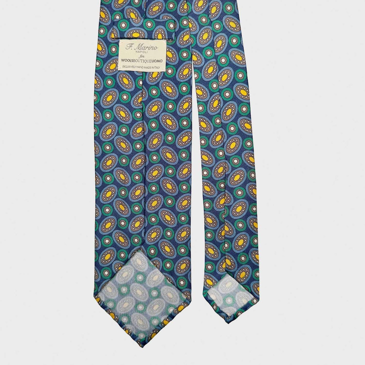 Élégante cravate en soie faite à la main avec un motif géométrique planétaire classique, fond bleu marine. Fabriqué en Italie avec un design exclusif créé par Wools Boutique Uomo à Genève