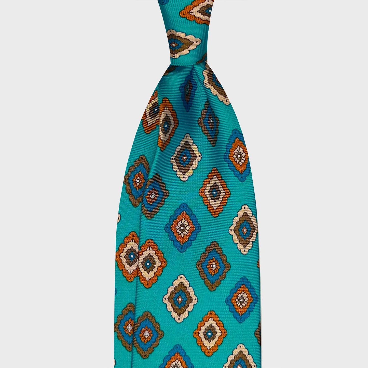 Cyan Silk Tie Classic Diamonds Pattern Genève. Classic silk tie cyan background with orange royal blue beige diamonds pattern, unlined 3 folds, handmade tie F.Marino Napoli for Wools Boutique Uomo Geneva