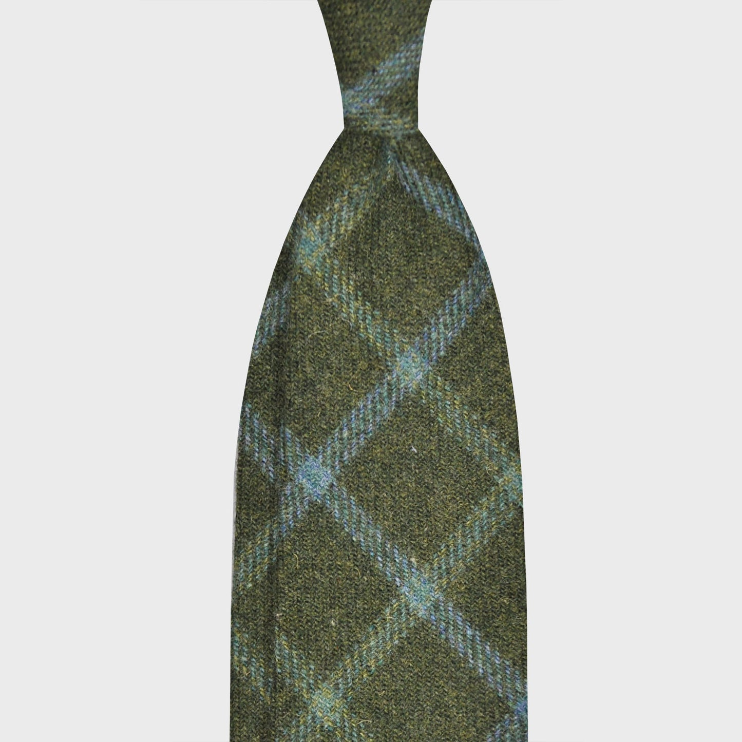 Windowpane Wool Tweed Tie Rifle Green Hand Made in Italy. Tweed wool tie discover in Wools Boutique Uomo Geneva, light tweed soft texture to the touch, green background with sky blue windowpane pattern, wool tie swiss