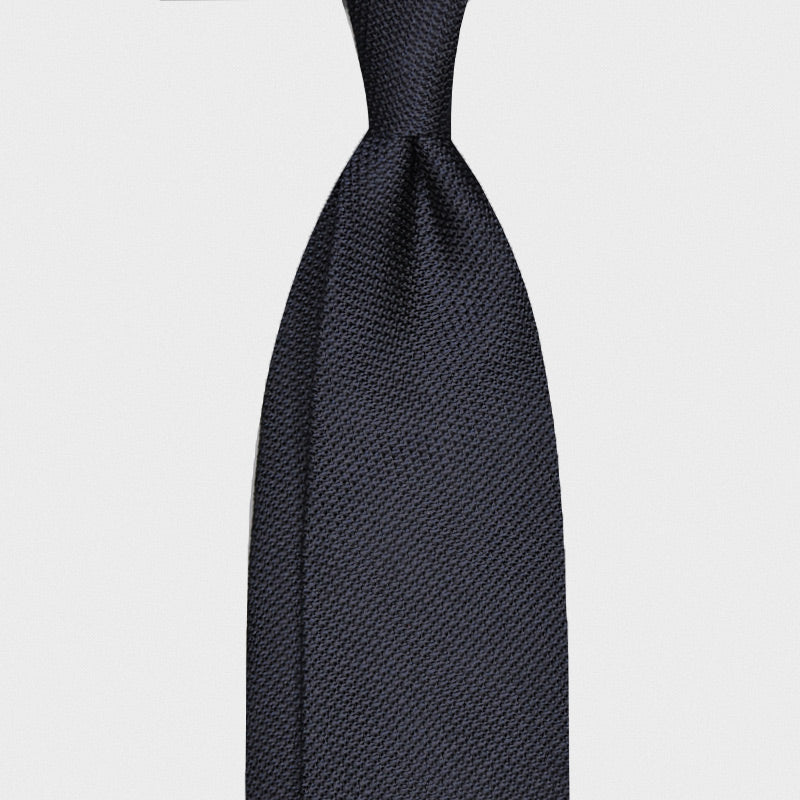 Cravate en grenadine de soie bleu marine unie, non doublée, fabriquée à la main en Italie. Disponible chez Wools Boutique Uomo, magasin de vêtements pour hommes à Genève.
Navy Blue Solid Color Tie Unlined Grenadine Silk. Refined handmade silk tie navy blue, grenadine silk tie solid color, unlined 3 folds hand rolled edge, F.Marino Napoli exclusive made in Italy for Wools Boutique Uomo Geneva