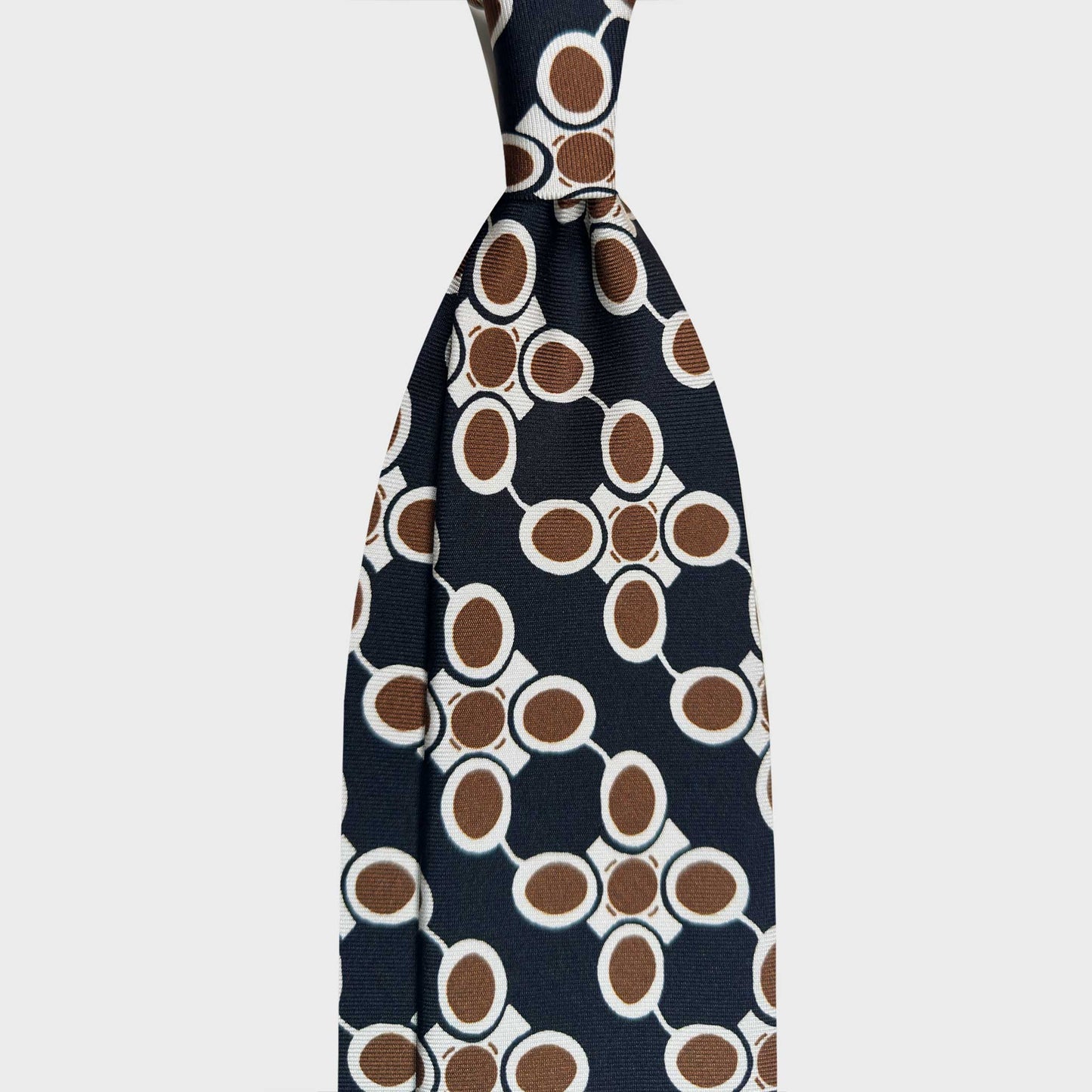 Black Silk Tie Art Deco Atomic Pattern 50s Industrial Design. Black silk tie featuring an Art Deco atomic pattern in white and coffee brown, inspired by 1950s industrial design and modernist interiors. Wools Boutique Uomo men's ties store in Geneva.