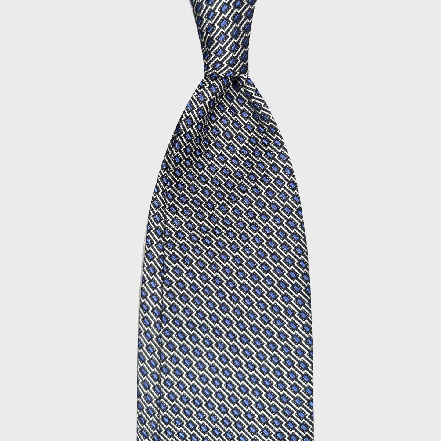Sky Blue Silk Tie Art Deco Geometric Men’s Clothing Boutique Geneva. Sky blue silk tie with refined Art Deco geometric pattern, handmade in Italy. Discover elegant ties at Wools Boutique Uomo Geneva.