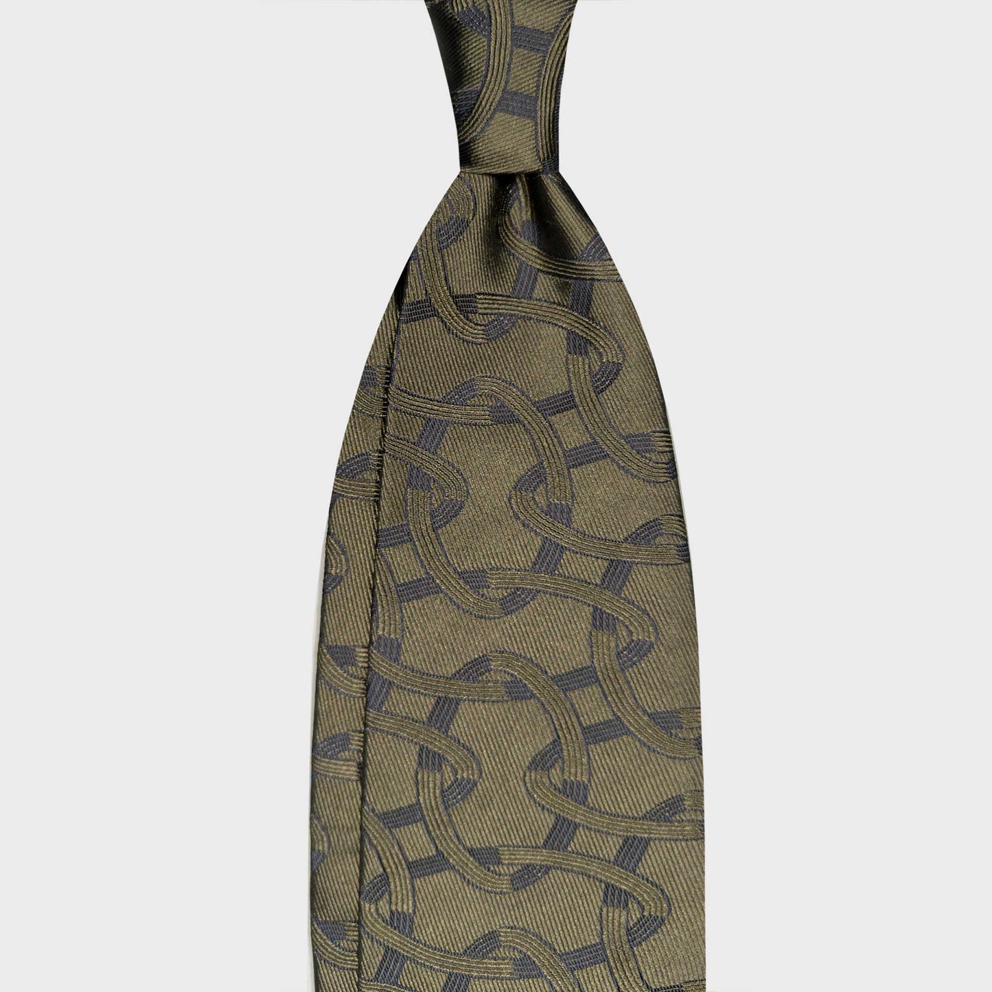 Loden Green Oval Chain Silk Tie Geneva Luxury Menswear. Loden green silk tie with an Art Déco oval chain pattern and navy details. Handmade in Italy and selected by Wools Boutique Uomo Geneva.