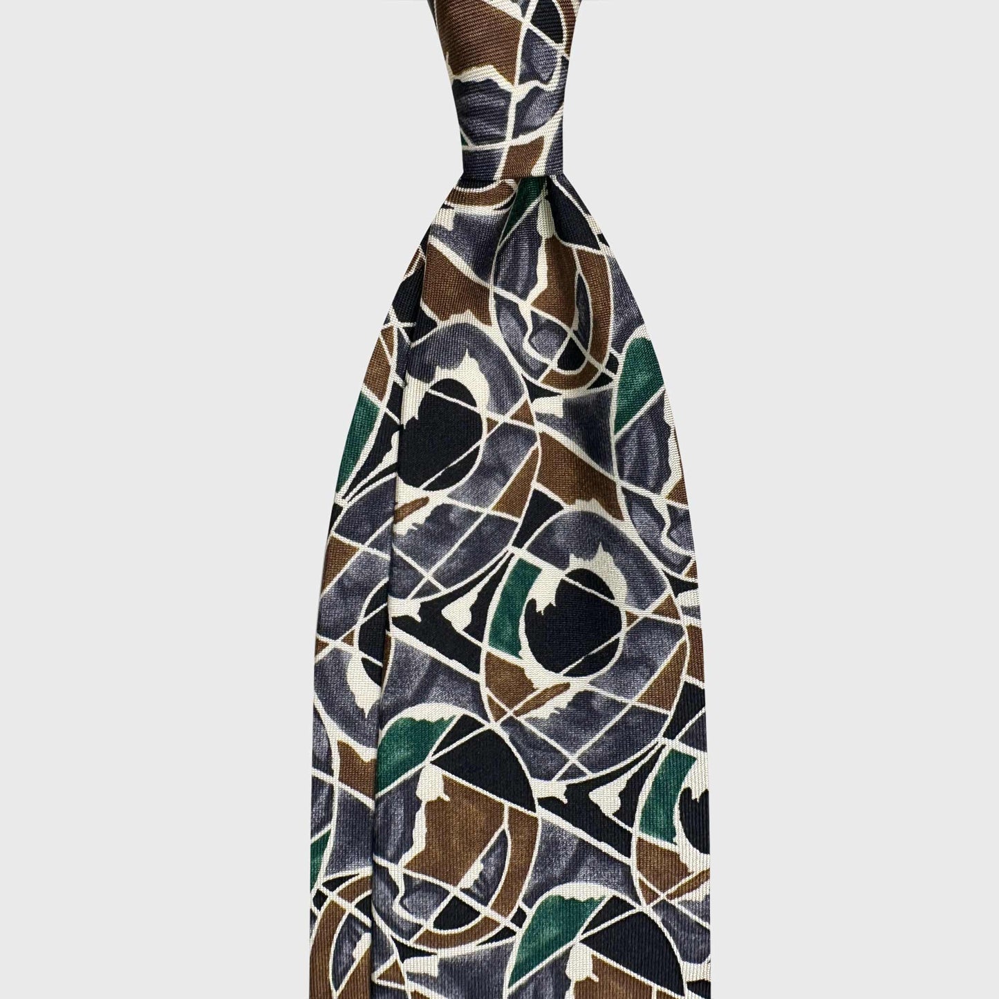 Black Bronze Green Silk Tie Artistic Tribal Geometry Design. Silk tie featuring an artistic tribal geometry motif in black bronze with green and grey tones. A bold contemporary piece for distinctive modern tailoring. Wools Boutique Uomo men's ties store in Geneva.