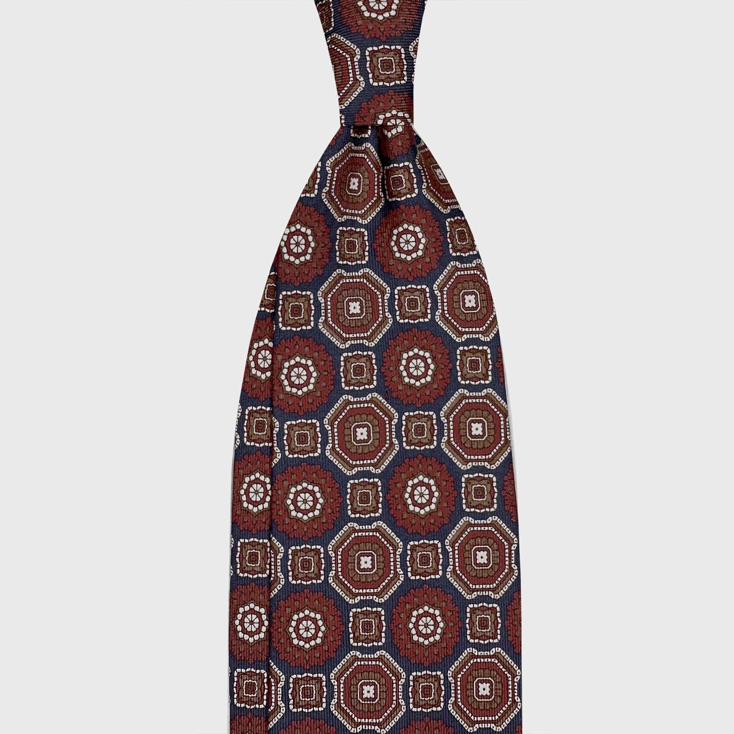 Navy Blue Maiolica Silk Tie Wools Boutique Uomo Geneva. Navy blue silk tie with a distinctive Maiolica inspired geometric pattern. Luxury men's accessories selected for timeless elegance and versatile tailoring.
