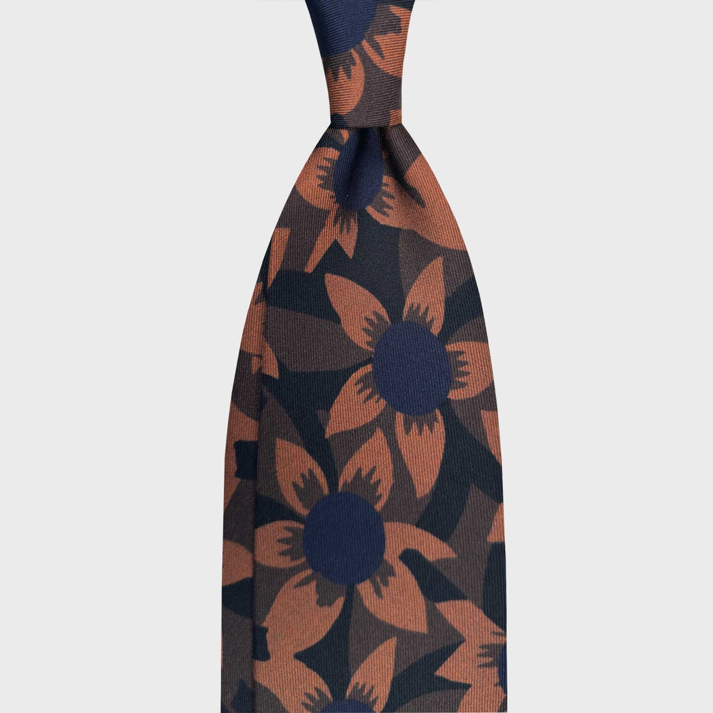 Black Silk Tie Graphic 70s Floral Design. Silk tie featuring a bold graphic 70s floral motif on black background with navy and ocra yellow tones. Handmade in Italy for distinctive sartorial elegance. F.Marino Napoli handmade ties available at Wools Boutique Uomo Geneva.