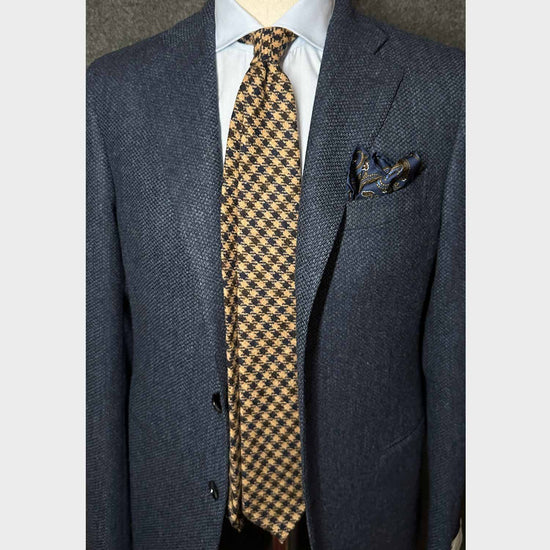 Camel Tweed Tie Classic Checked. Classic tweed tie, wool texture to the touch bristly feeling, unlined checked wool tie handmade in Italy by F.Marino Napoli exclusive for Wools Boutique Uomo, camel tobacco background, denim blue and coffee brown checked pattern.