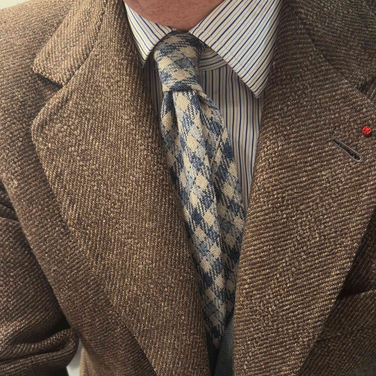 Checked Wool Tie Denim Blue Shetland Tweed. Shetland tweed checked tie in dusty denim blue and warm ivory. Handmade in Italy and selected by Wools Boutique Uomo Geneva for refined autumn and winter tailoring.
