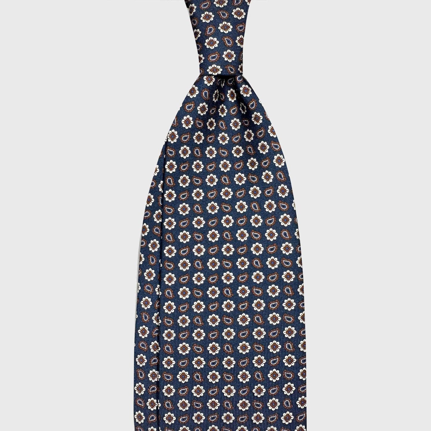 Classic Navy Blue Silk Tie Micro Daisy and Paisley Pattern. Blue silk tie with micro daisy and paisley pattern. Handmade in Italy and selected by Wools Boutique Uomo Geneva for elegant business and sartorial clothing.