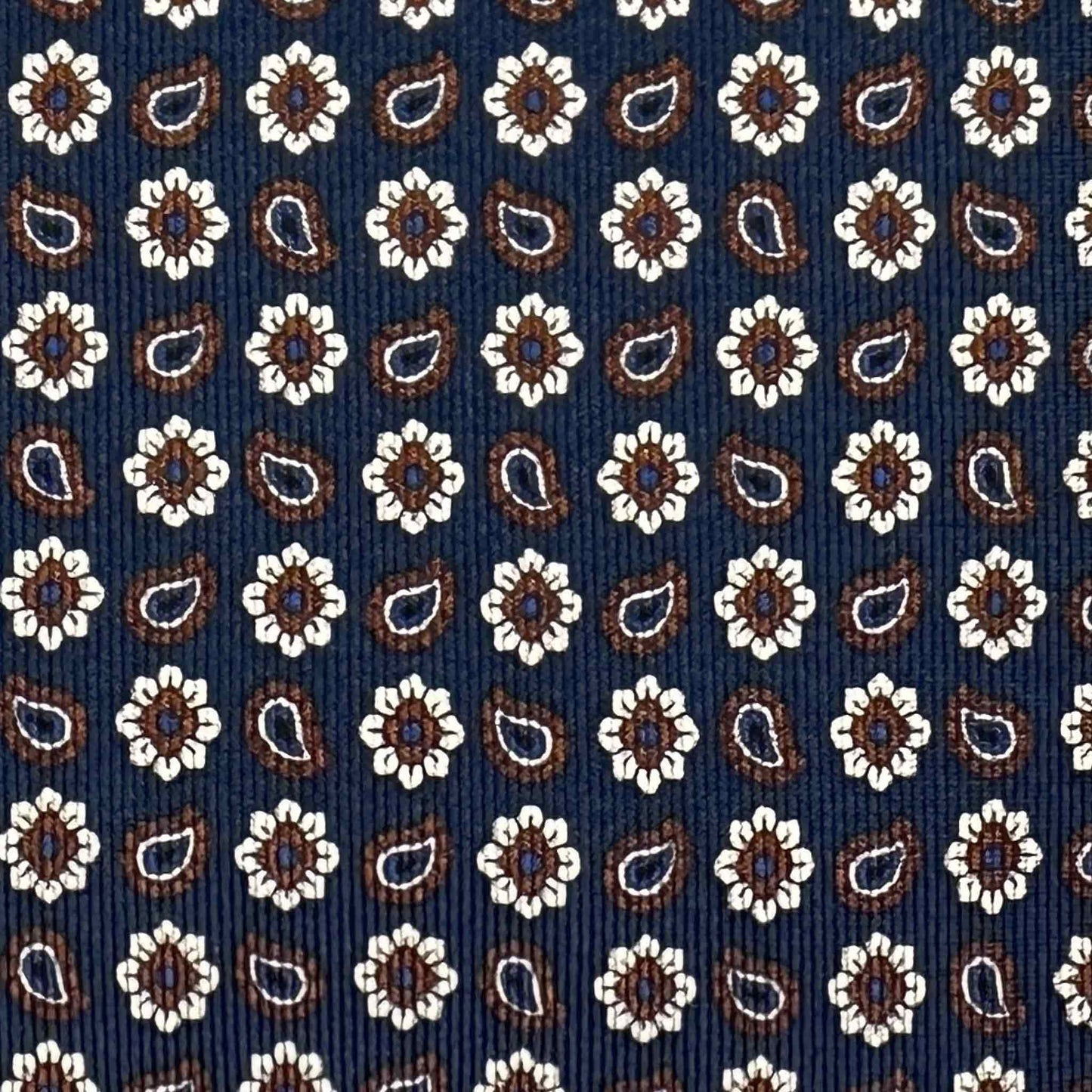 Detail of navy blue silk tie with micro daisy and paisley pattern