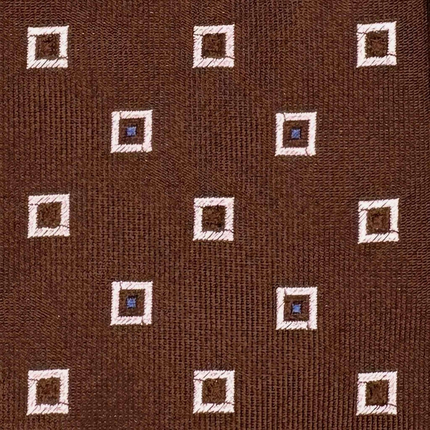 Detail of mini frame pattern silk tie in coffee brown with white and light blue geometric motifs