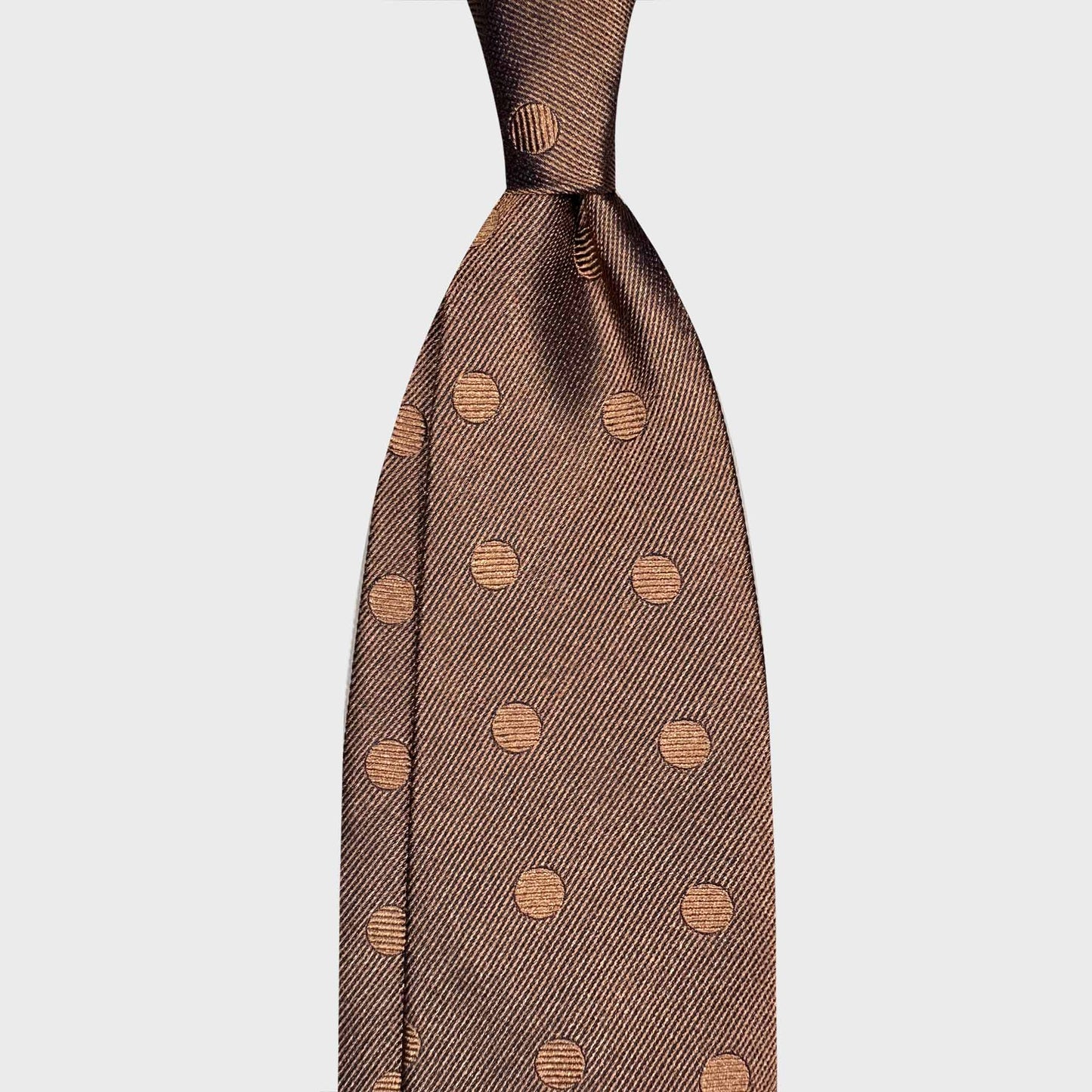 Copper Brown Silk Tie Bold Pois Wools Boutique Uomo Geneva. Elegant copper brown silk tie with bold tone-on-tone pois pattern. Handmade in Italy and selected by Wools Boutique Uomo Geneva for refined sartorial wardrobes.