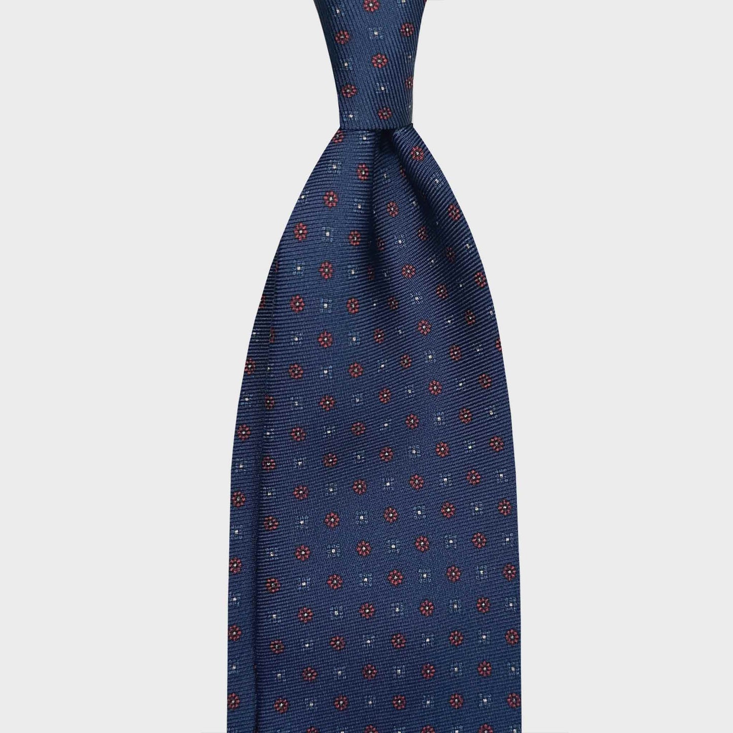 Blue Madder Silk Tie 7 Folds Light Blue Red Micro Fantasy. Handmade 7 fold silk tie, blue background, light blue micro diamonds, red micro daisy, seven folds silk ties F.Marino Napoli for Wools Boutique Uomo Genève