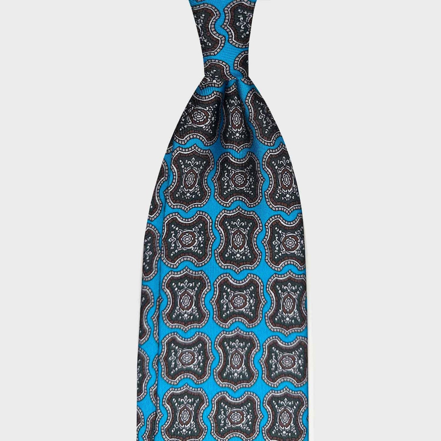 Cloisonné Blue Silk Tie Madallion Pattern Made in Italy. Refined cloisonné blue men silk tie with brown and loden green medallions pattern, handmade tie shop Wools Boutique Uomo Genève