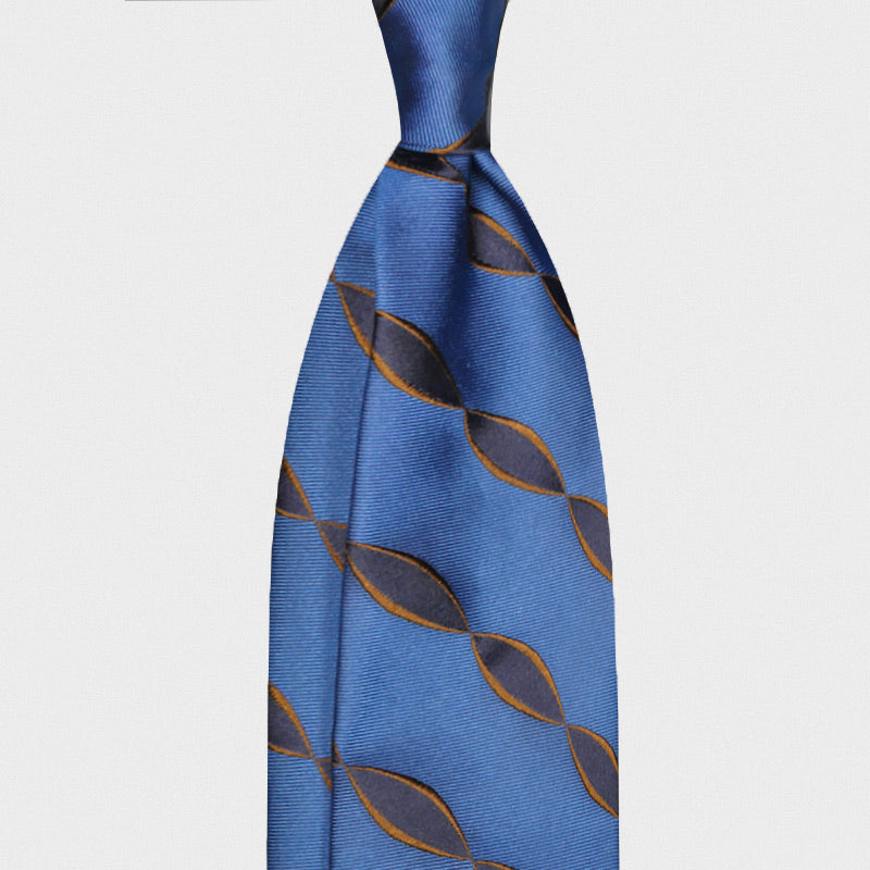 Electric Blue Silk Tie Art Deco Helix Pattern Navy Bronze. Electric blue silk tie featuring an Art Deco helix pattern with navy and bronze interlocking motifs. A bold geometric Italian design ideal for distinctive business and contemporary sartorial styling. Wools Boutique Uomo men's ties store in Geneva.