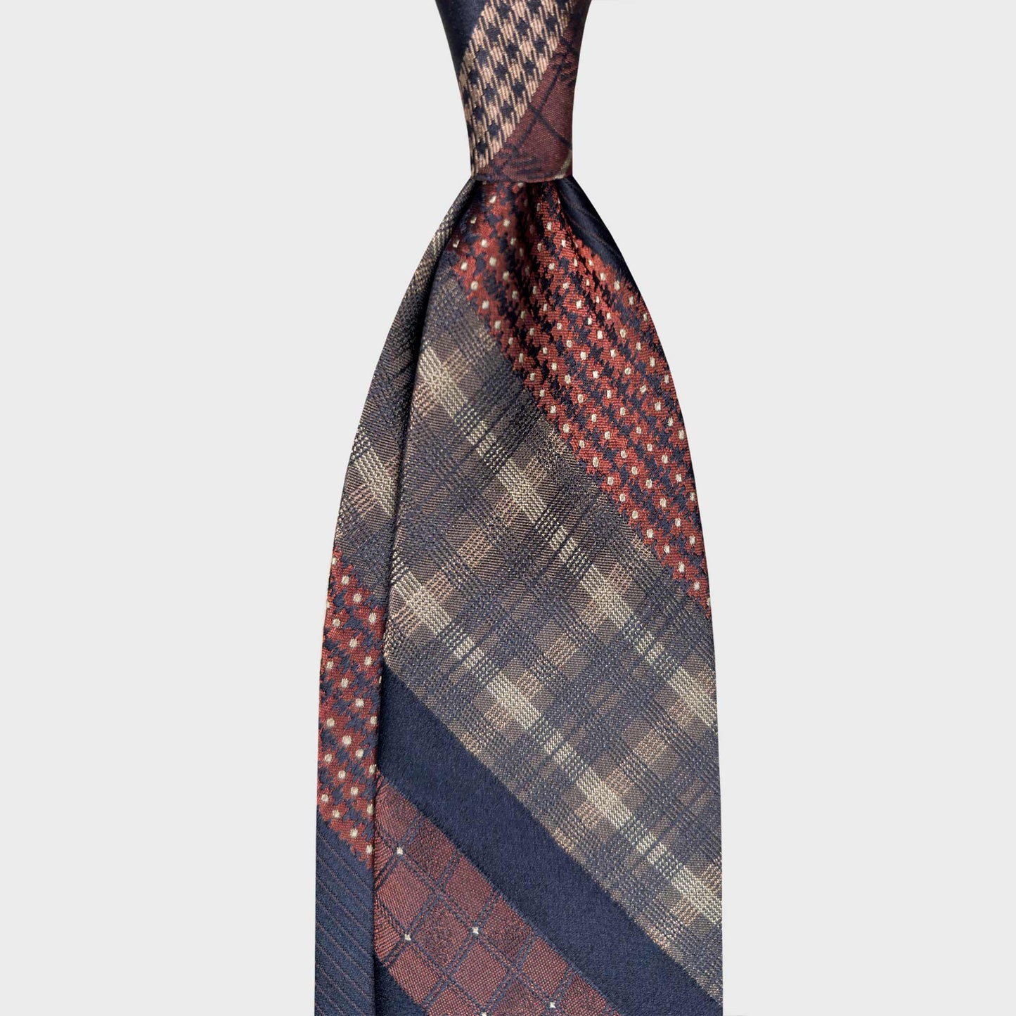 Printed Patchwork Regimental Silk Tie Handmade in Italy. Exclusive and original striped silk tie, printed patchwork pattern, antique gold checks with navy blue stripe and burgundy micro floral details. F. Marino Napoli ties are available at Wools Boutique Uomo Geneva.
