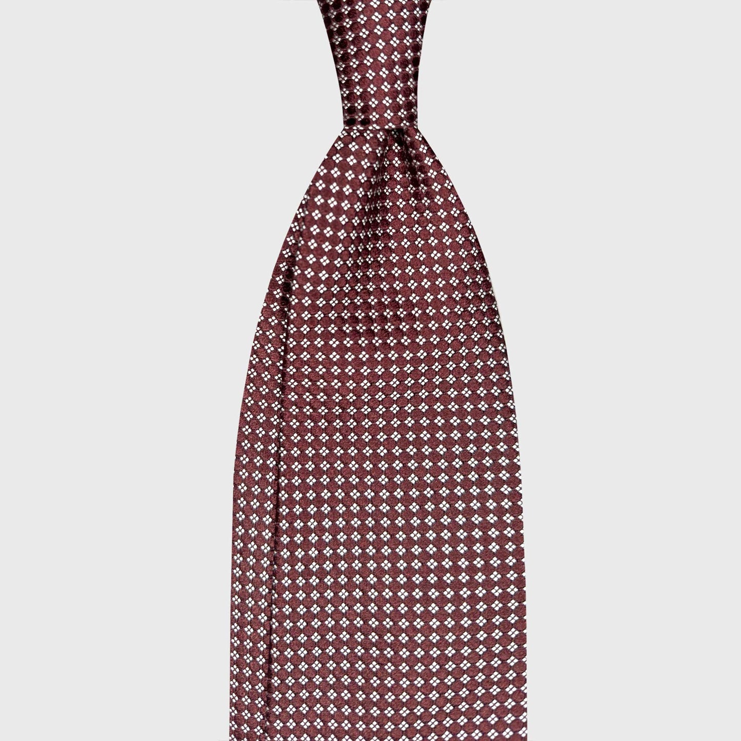 Made in Italy Silk Tie Classic Burgundy Micro Diamonds Pattern. Burgundy silk tie with refined micro diamond pattern. Handmade in Italy and curated by Wools Boutique Uomo Geneva for elegant business and formal outfits.