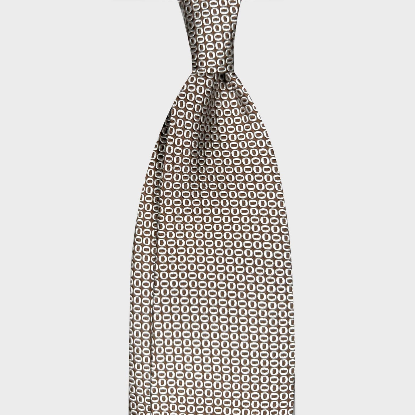Silk Tie Shop Suisse Micro Oval Pattern Art Deco Coffee Brown. Elegant coffee brown silk tie with refined micro oval pattern. Handmade Italian tie curated by Wools Boutique Uomo Geneva for distinctive modern style.