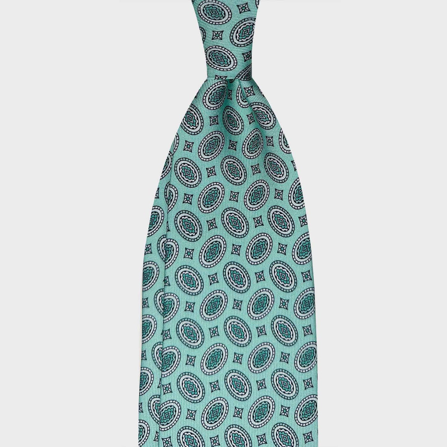Water Leaf Silk Tie Oval Diamonds Genève. Refined silk tie with water leaf color background, black and dark water leaf oval diamonds pattern, handmade tie shop Wools Boutique Uomo Geneva