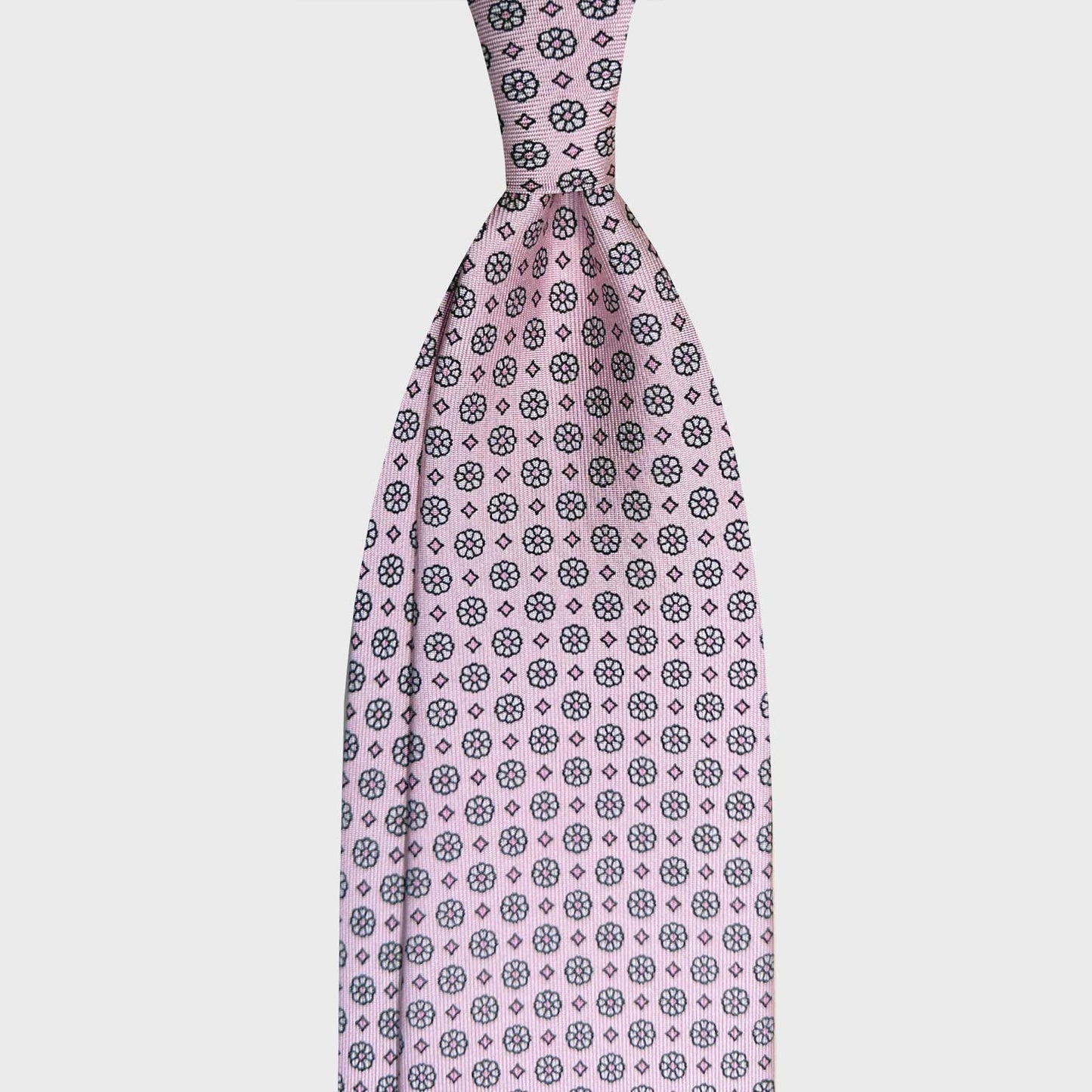 Light Pink Silk Tie Classic Micro Daisy Pattern Shop Genève. Elegant silk tie light pink background with black micro daisy pattern, unlined 3 folds, handmade tie F.Marino Napoli for Wools Boutique Uomo Geneva