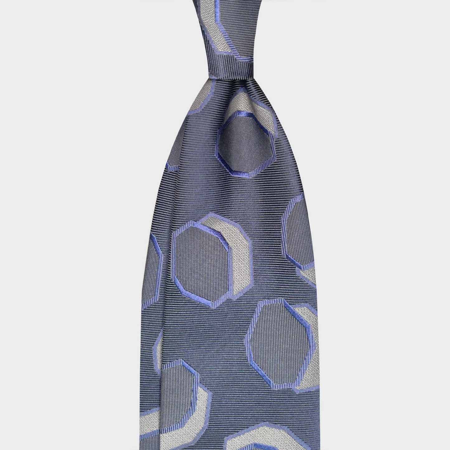 Silver silk tie featuring an Art Deco octagon pattern in ivory and violet tones. A refined geometric design crafted in Italy, ideal for elegant business attire and contemporary formal styling.