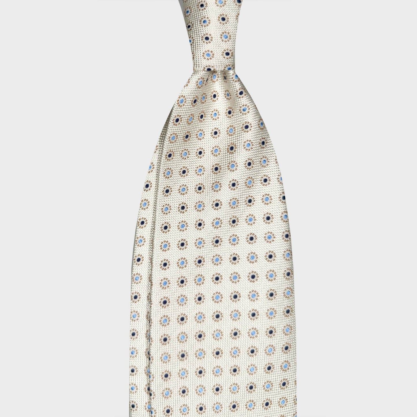 Ivory White Silk Tie Micro Circle Men's Clothing Boutique Geneva. Ivory white silk tie with micro circle pattern in beige, navy and sky blue. Handmade in Italy, curated by Wools Boutique Uomo Geneva Switzerland.