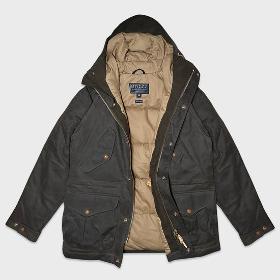 Coffee Brown Padded Wax Cotton Fisherman Parka. Men's fisherman parka made of water repellent waxed cotton, handmade in Italy by Manifattura Ceccarelli for Wools Boutique Uomo Geneva, an mens outerwear coffee brown color with medium length that never goes out of fashion, protective and warm.