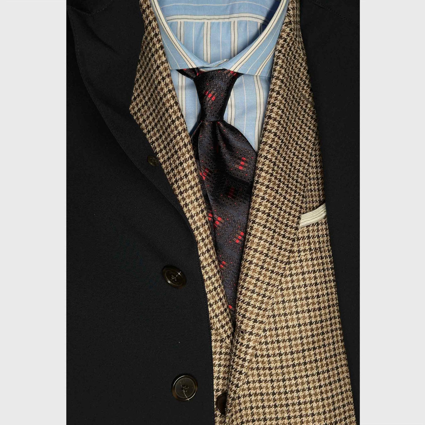 A refined tie defined by structure and depth is built on a rich dark coffee brown silk base, enhanced by a geometric windowpane pattern in deep navy blue tones and refined red accents.