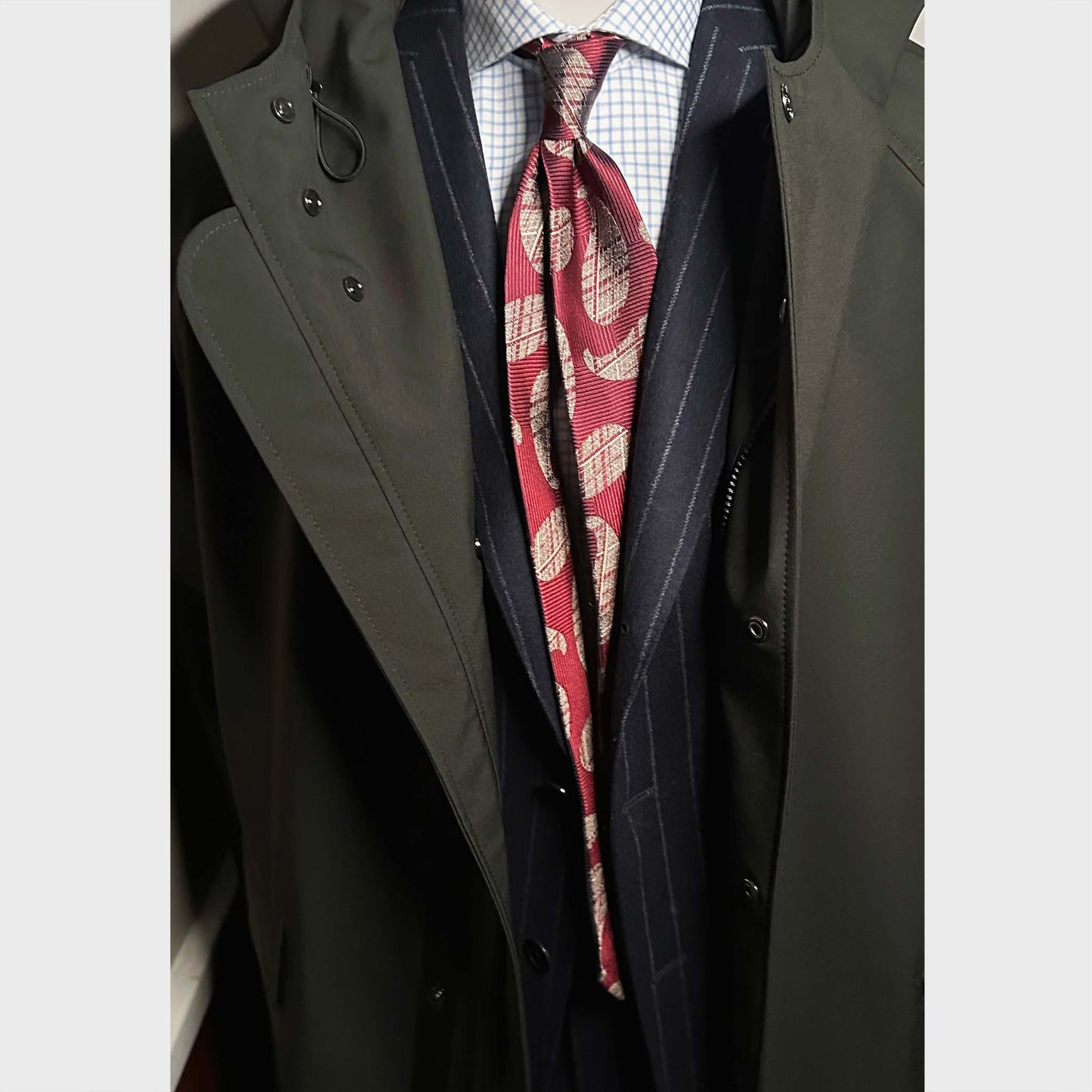 Men's outfit with Ruby red silk tie featuring large silver paisley motifs with refined woven texture. 