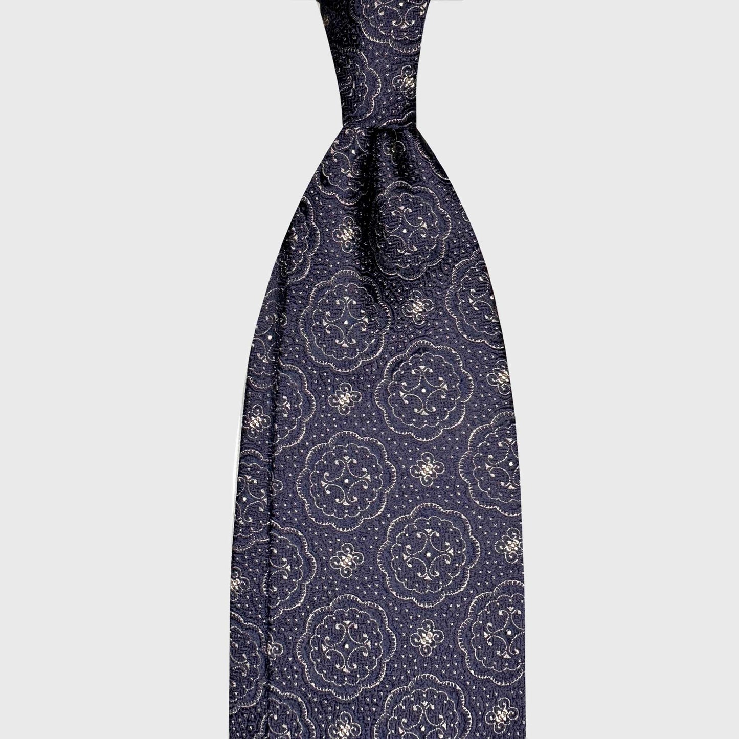 Navy Blue Medallions Silk Tie Wools Boutique Uomo Geneva. Elegant navy blue silk tie featuring a refined medallions pattern in contrasting white. A timeless accessory for business attire and classic tailoring.