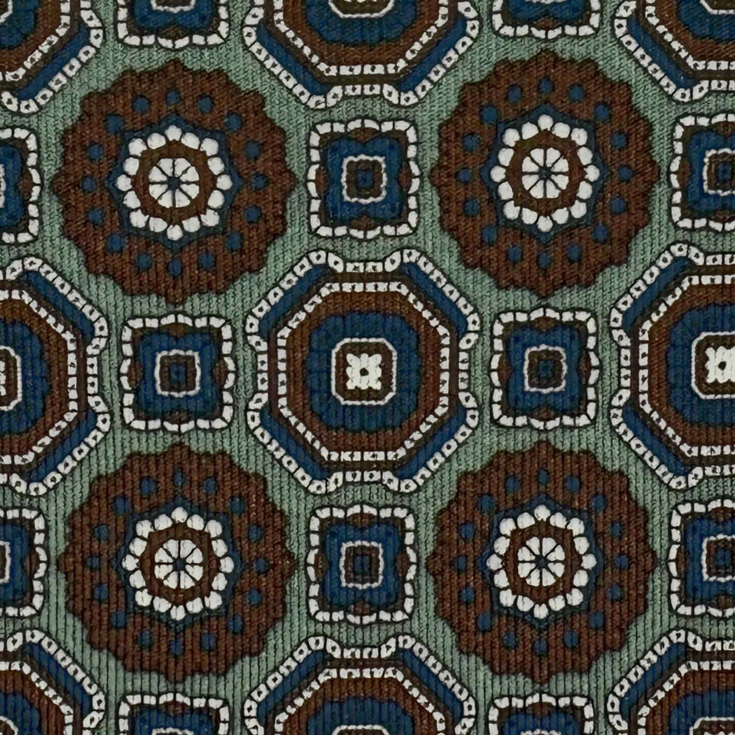 Detail of sage green silk tie with navy blue and tobacco maiolica motif
