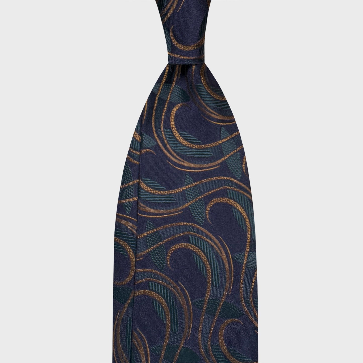 Navy blue silk tie featuring an ornamental Art Nouveau design in antique gold and deep teal tones. A sophisticated jacquard pattern with fluid lines, ideal for elegant business attire and refined evening menswear. Wools Boutique Uomo men's ties store in Geneva.
