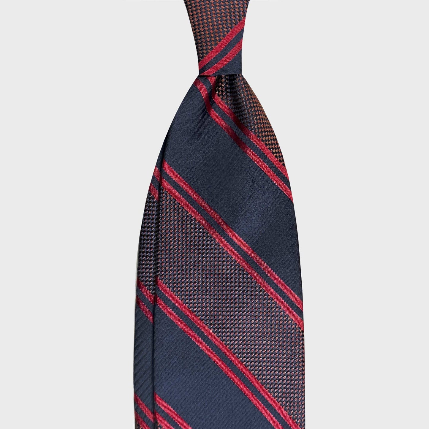 Discover refined Italian ties at Wools Boutique Uomo Geneva. This F.Marino silk regimental tie in navy blue, coffee brown and red stripes is a timeless accessory for business and classic tailoring.