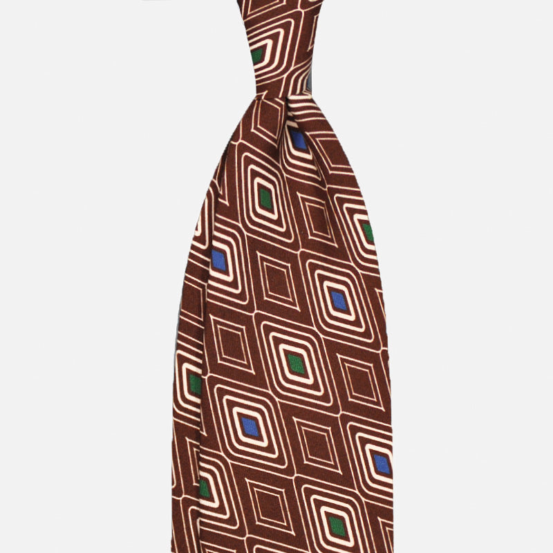 Brown silk tie featuring an Art Deco rhombus pattern with cobalt blue and green diamond accents. A refined geometric design inspired by vintage elegance, ideal for distinctive business styling.