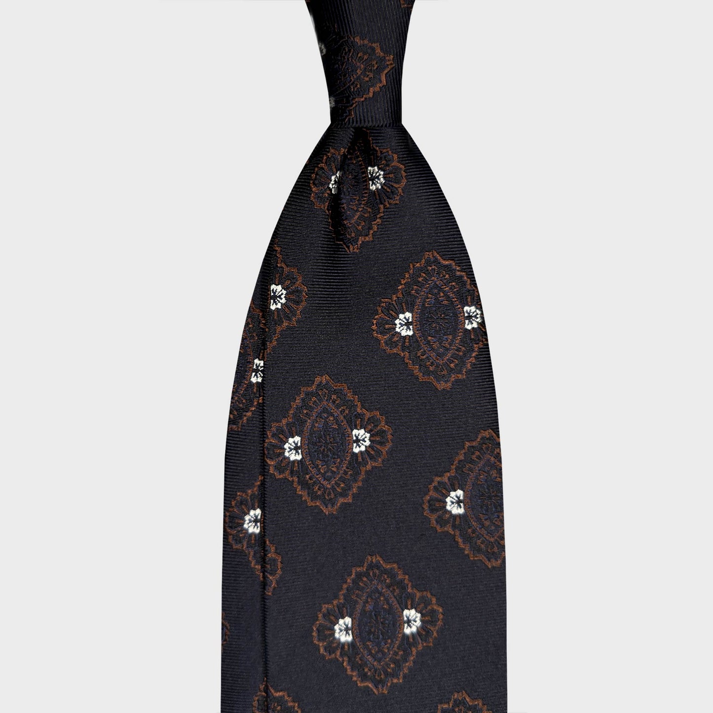 Blue Silk Tie Large Medallions Pattern Heritage Style. Dark navy blue silk tie with large brown medallions and silver grey accents. Handmade in Italy and selected by Wools Boutique Uomo, Geneva ties shop.