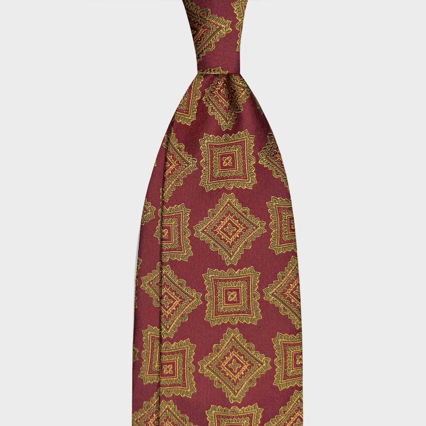 Burgundy Silk Tie Medallions Pattern Heritage Style. Burgundy silk tie with vintage medallions in lime green and yellow gold. Handmade in Italy and selected by Wools Boutique Uomo Geneva ties store.