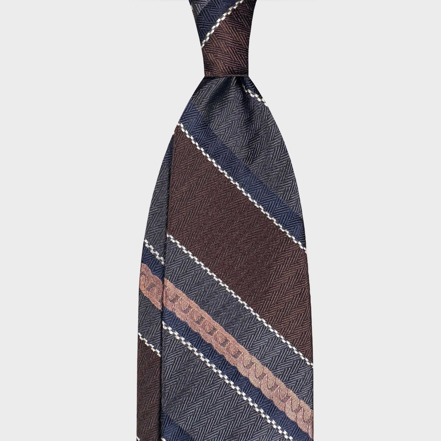 Discover Italian handmade ties at Wools Boutique Uomo Geneva. This F.Marino regimental silk tie in coffee brown and smoke grey is crafted in Naples and perfect for refined business tailoring.
