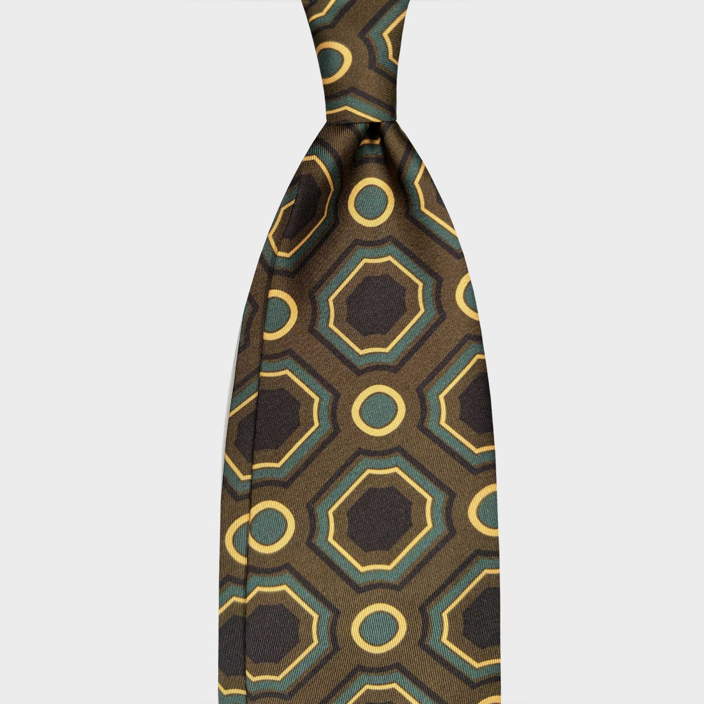 Maiolica Pattern Silk Tie Mud Green Handmade in Italy. Refined silk tie featuring a maiolica-inspired geometric pattern in mud green. Handmade in Italy and selected by Wools Boutique Uomo Geneva.