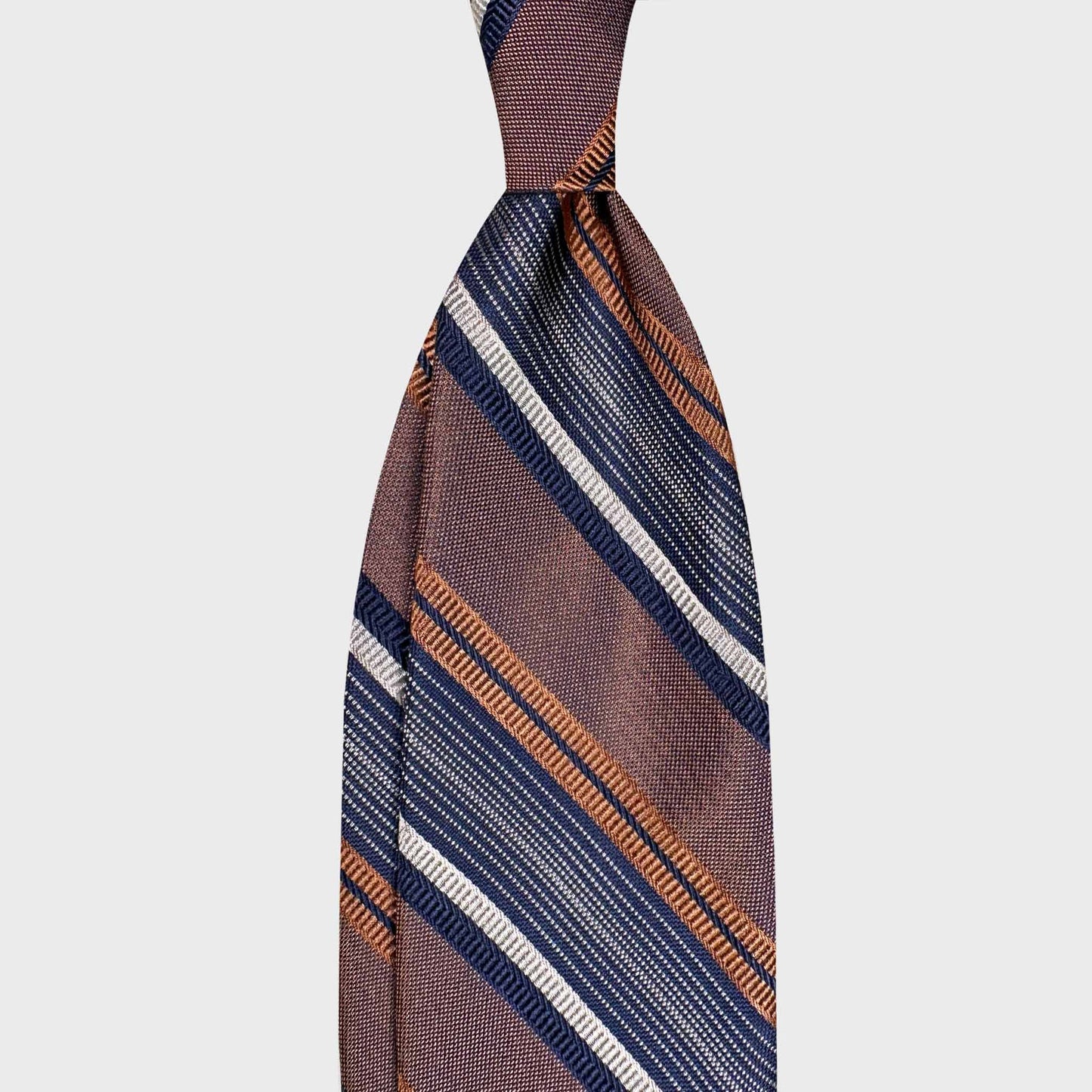 Discover F.Marino silk regimental ties at Wools Boutique Uomo Geneva. Made in Italy with elegant caramel brown, navy and ivory stripes — a timeless accessory for refined tailoring.