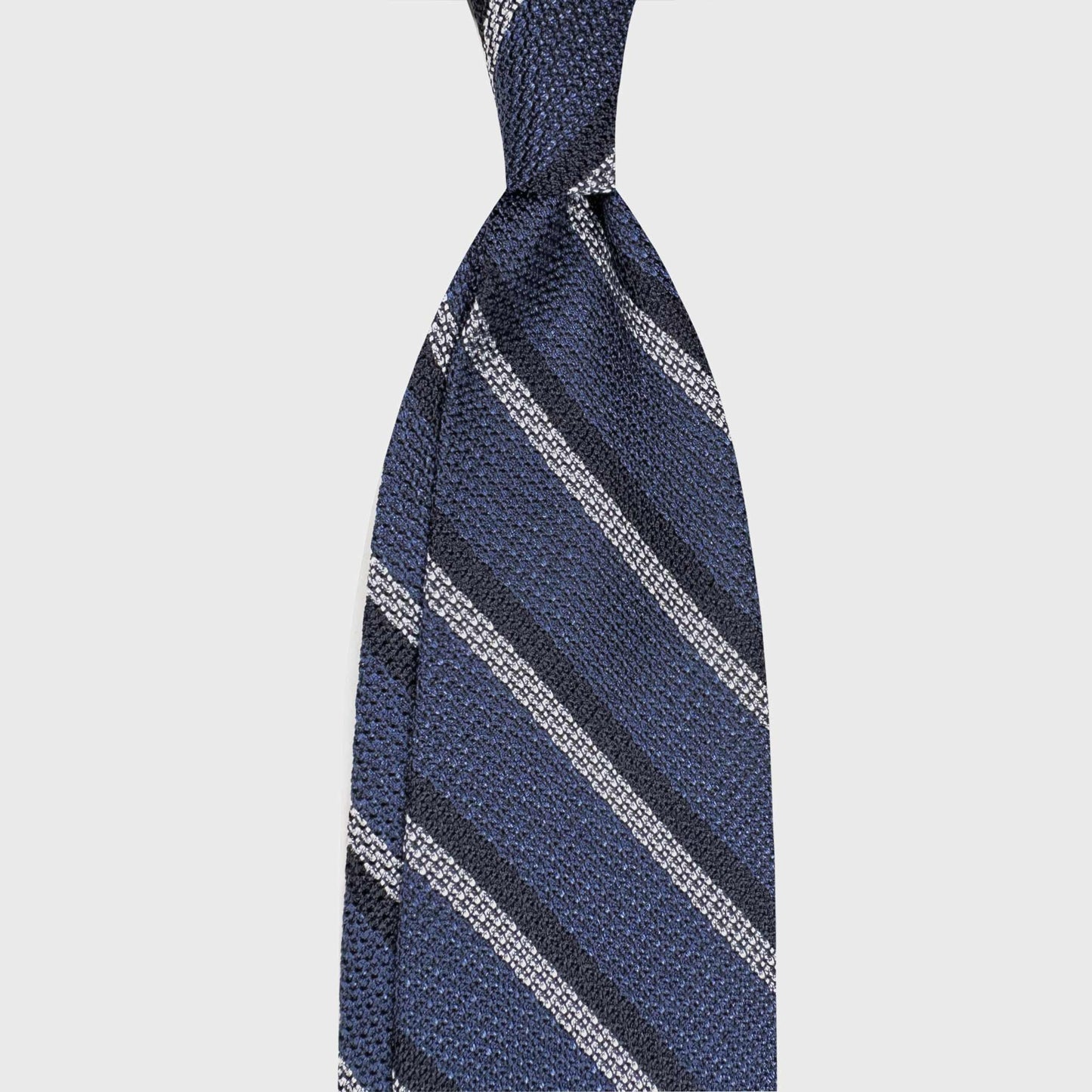 Handmade F.Marino grenadine silk regimental tie in denim blue with navy and silver stripes. Crafted in Naples for Wools Boutique Uomo Geneva.