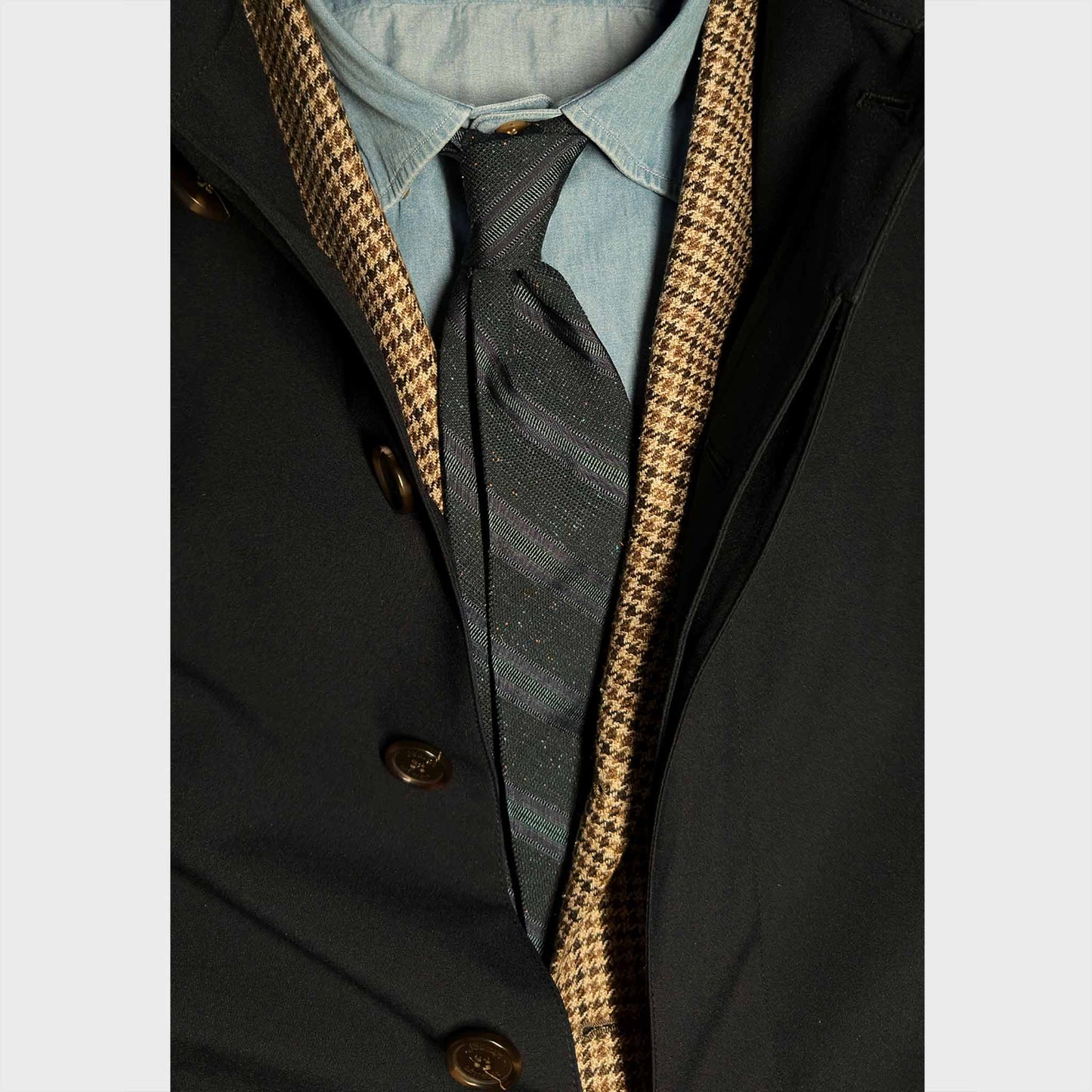 Men's suit with a navy blue forest green regimental Donegal effect silk tie. Discover in the Wools Boutique Uomo tie shop in Geneva.